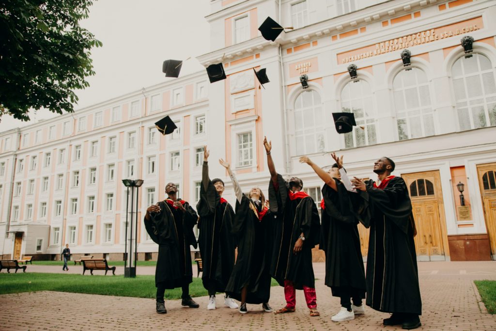 Image of a group of young adults graduating from college and throwing their caps in the air. If you are dealing with a major life transition, work with a skilled therapist in life transition therapy in Austin, TX so they can help support you.